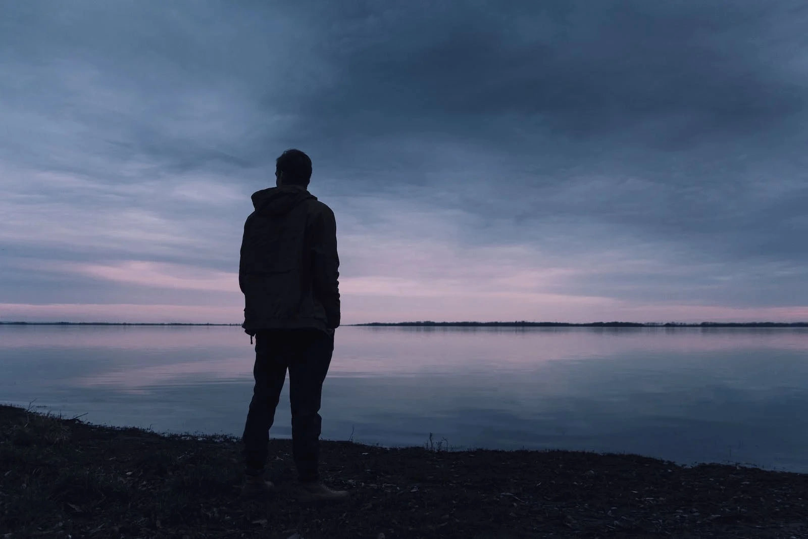 person standing next to water in darkness