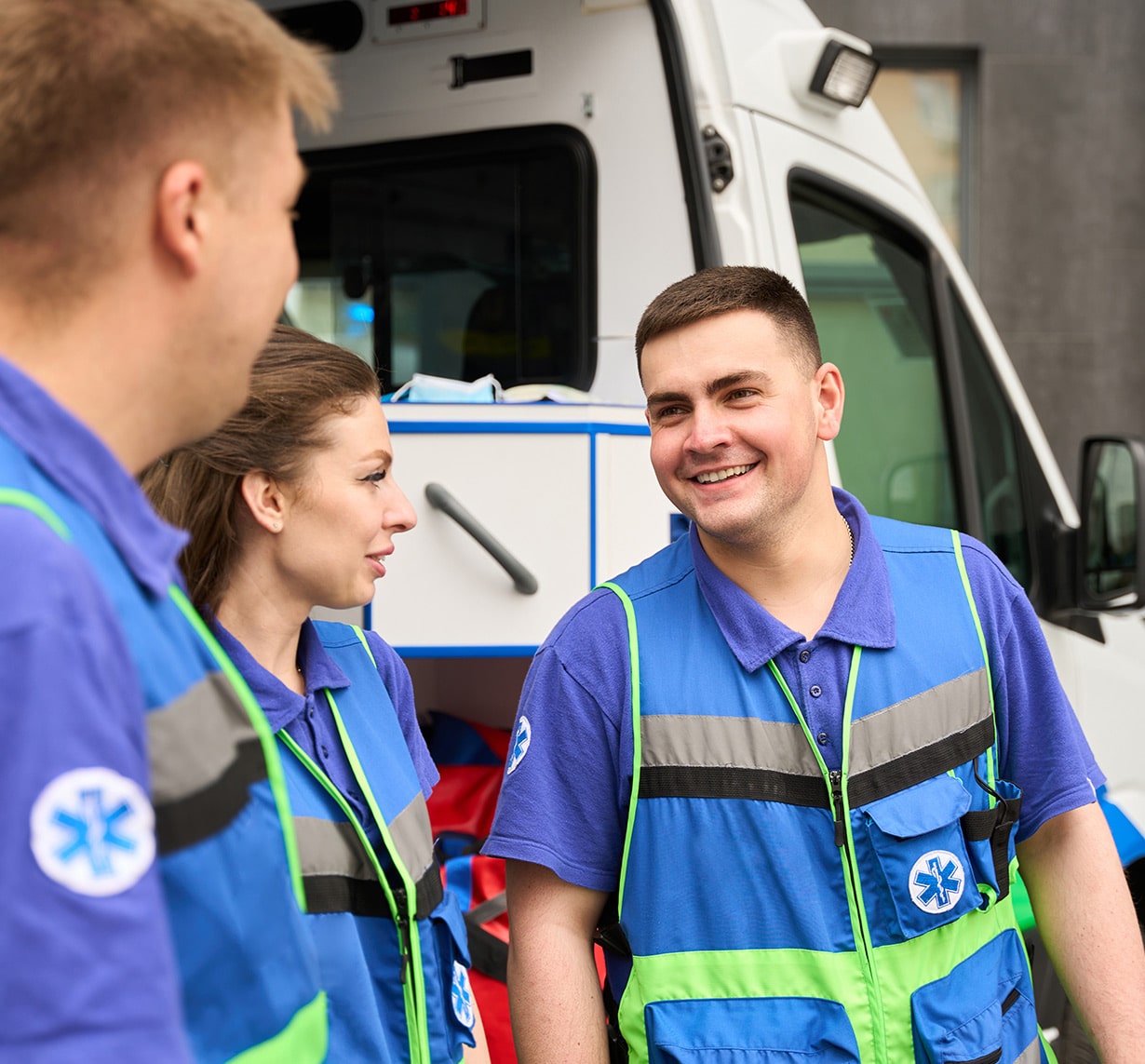 First responders sharing a lighthearted moment outside an ambulance, representing support for PTSD treatment at East Texas Ketamine Specialists
